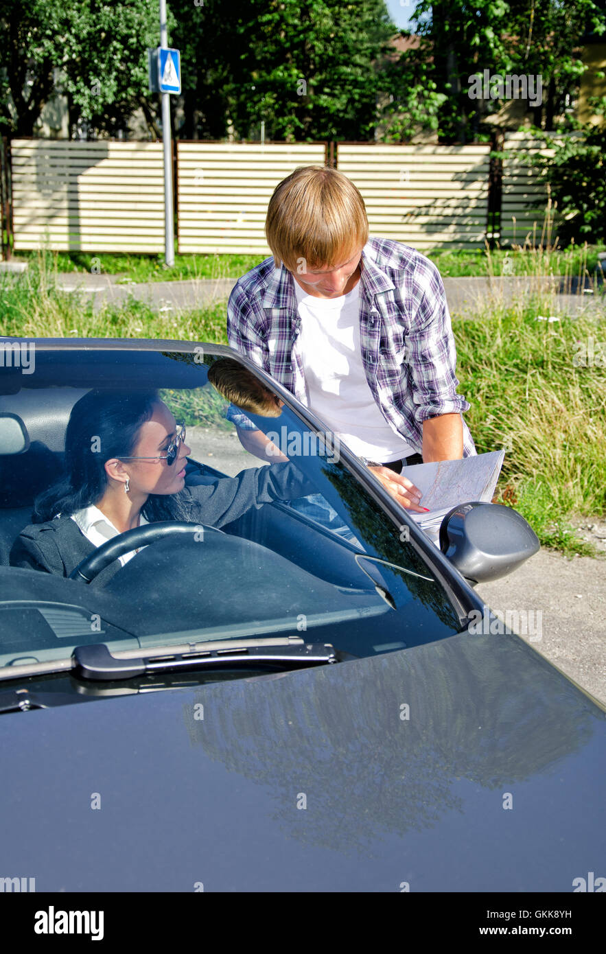 Maschio chiedendo turistica driver femminile circa la direzione Foto Stock