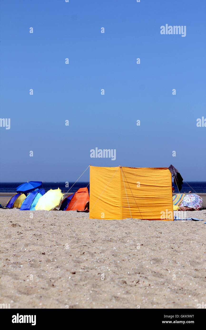 Varie protezione solare marcia alla spiaggia Foto Stock
