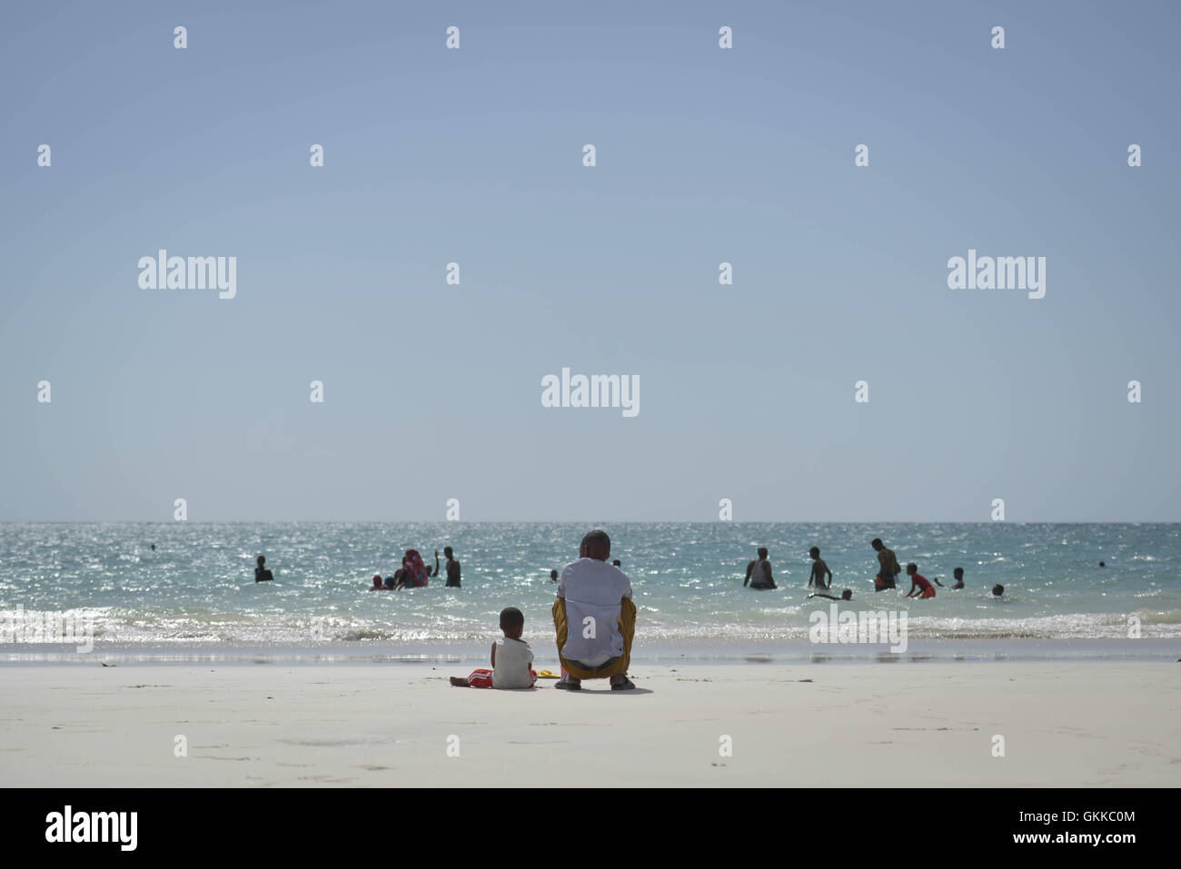 Il 21 dicembre, un padre e un figlio sono visti seduti sul mare a Lido Beach a Mogadiscio, godendo della vista costiera. La spiaggia è un luogo popolare per la gente del posto, dove rilassarsi e connettersi con la natura nella capitale somala. Foto Stock