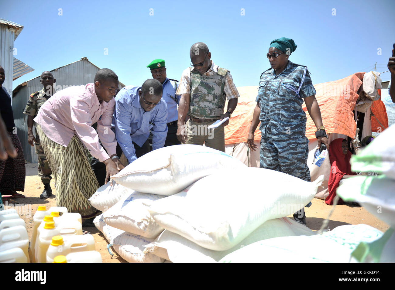 Senior Liason umanitario Officer, Abdul Diabagate, e Vice Supritendant Stella Sedame mostrano alcuni dei beneficiari di una dispensa alimentare dove al loro posto in corrispondenza di un IDP camp, Siliga Amerikanka, il 24 febbraio 2014. Un gruppo di singole forze di polizia AMISOM ufficiali alcune raccolte di denaro tra di loro e hanno comprato i prodotti alimentari per una comunità di 50 persone non vedenti. Foto Stock