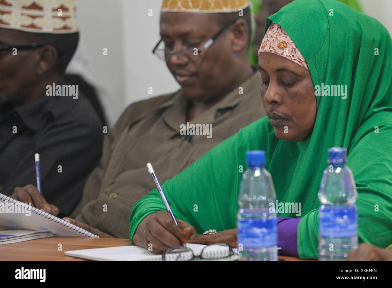 Un responsabile della formulazione della Somalia Politica di tutela dei minori workshop a Mogadiscio il 20 agosto 2014 prende appunti. AMISOM foto / David Mutua Foto Stock