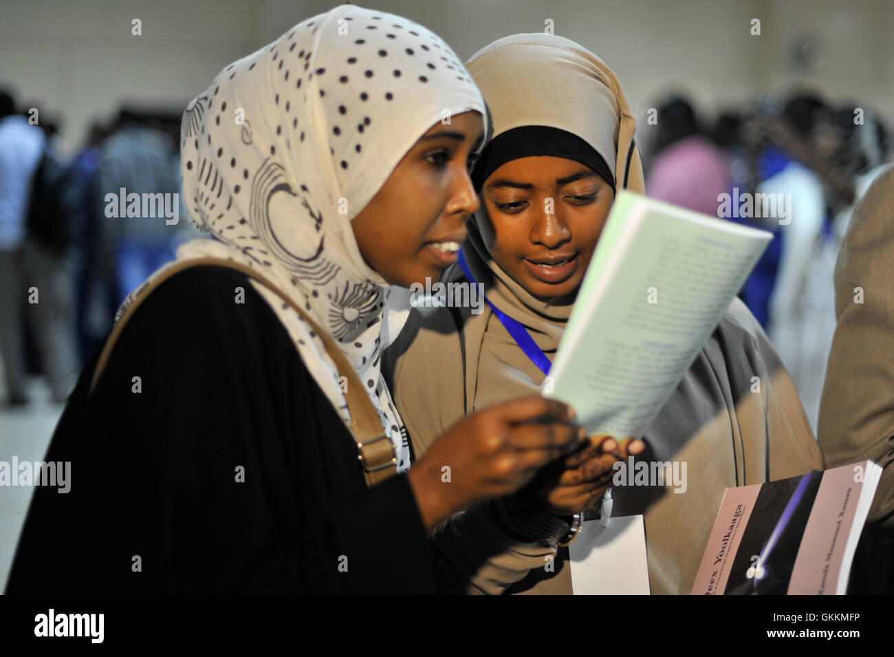 Gli appassionati di lettura check out libri in vendita durante la Mogadiscio Fiera Internazionale del Libro tenutasi a Mogadiscio, Somalia il 26 agosto 2015. Mogadiscio detenuti è il primo salone del libro per celebrare i libri, letteratura e il rilancio di espressione umana della società somala. La fiera mira a esporre la gioventù internazionale e letteratura somala e far crescere una nuova generazione di alfabetizzazione e persone creative desiderosi di contribuire allo sviluppo della comunità. AMISOM foto / Ilyas Ahmed Foto Stock