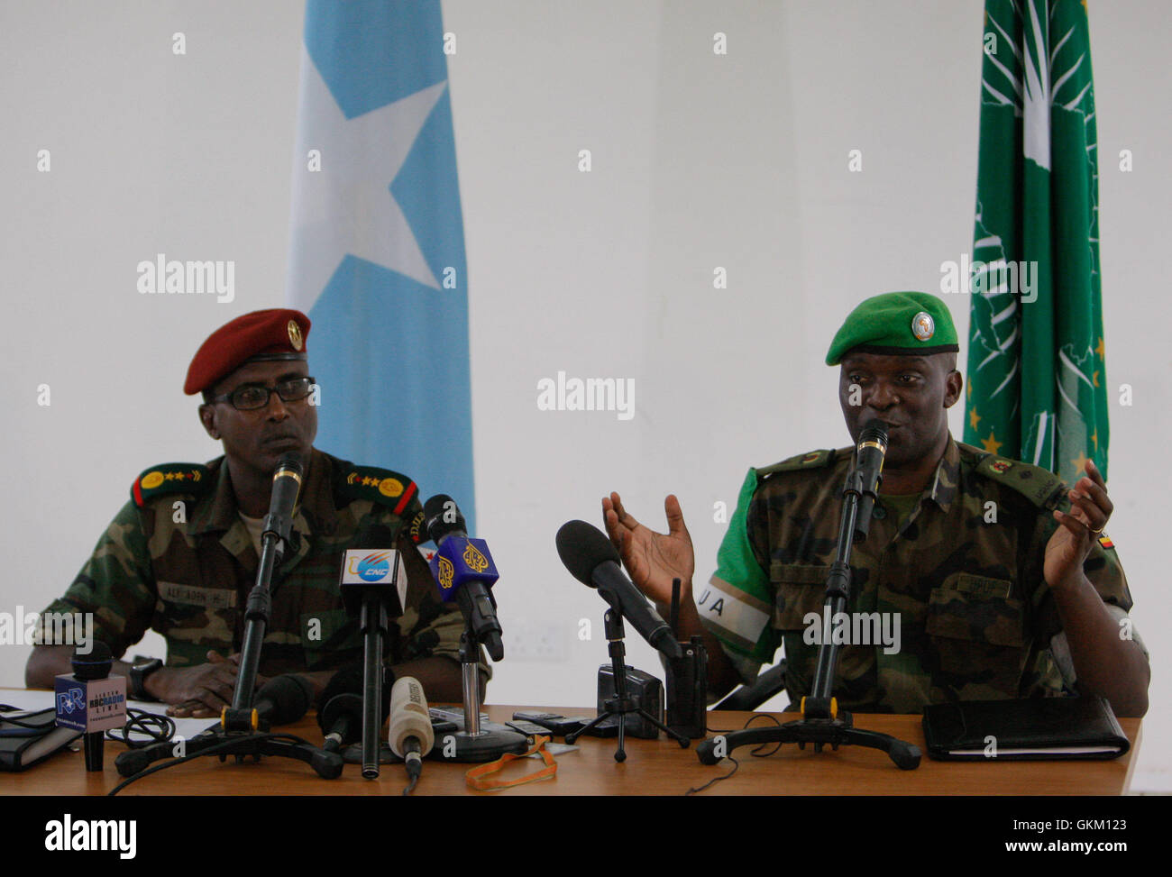 SOMALIA, Mogadiscio: In un photgraph rilasciato dall'African Union-United Nazioni Informazioni sul team di supporto, in uscita missione dell Unione Africana in Somalia (AMISOM) portavoce Lt. Col. Paddy Ankunda (destra) gesti durante una pressa breifing per introdurre il suo successore, il Colonnello Ali Aden Houmed dell'abitante del Gibuti Forze Armate (sinistra) 07 luglio, presso la missione presso la sede centrale nella capitale somala Mogadiscio. Il colonnello Ali sostituisce Lt. Col. Ankunda chi è stato AMISOM portavoce a partire dal mese di aprile 2011, come AMISOM espande le sue aree di funzionamento al di fuori di Mogadiscio con il nuovo quartier generale del settore ora in Baidoa, Beletweyne un Foto Stock