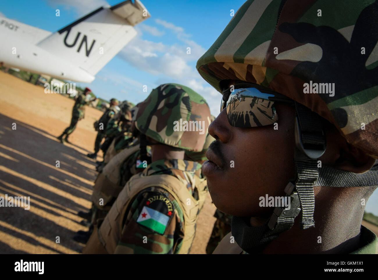 SOMALIA, Belet Weyne: In una fotografia rilasciato dall'African Union-United Nazioni Informazioni sul team di supporto 16 novembre, la zona circostante è riflesso negli occhiali da sole di un soldato dal contingente del Gibuti che serve con la missione dell Unione Africana in Somalia (AMISOM) all'aeroporto del centro città somala di Belet Weyne, circa 300km a nord-ovest della capitale somala Mogadiscio durante l'arrivo di ulteriori truppe del Gibuti a AMISOM settore 4. L'aria di sollevamento è parte di una distribuzione per iniziare a incrementare il proprio oltre 300 personale già sulla terra per circa 1.000 truppe che serve unde Foto Stock