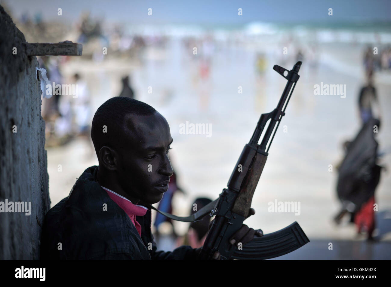 Una guardia armata osserva la sicurezza a Lido Beach a Mogadiscio, in Somalia, durante le celebrazioni Eid-UL-Fitr l'8 agosto. L'evento ha segnato una vacanza tranquilla per la popolazione somala, un'occasione significativa nel calendario musulmano. Foto Stock