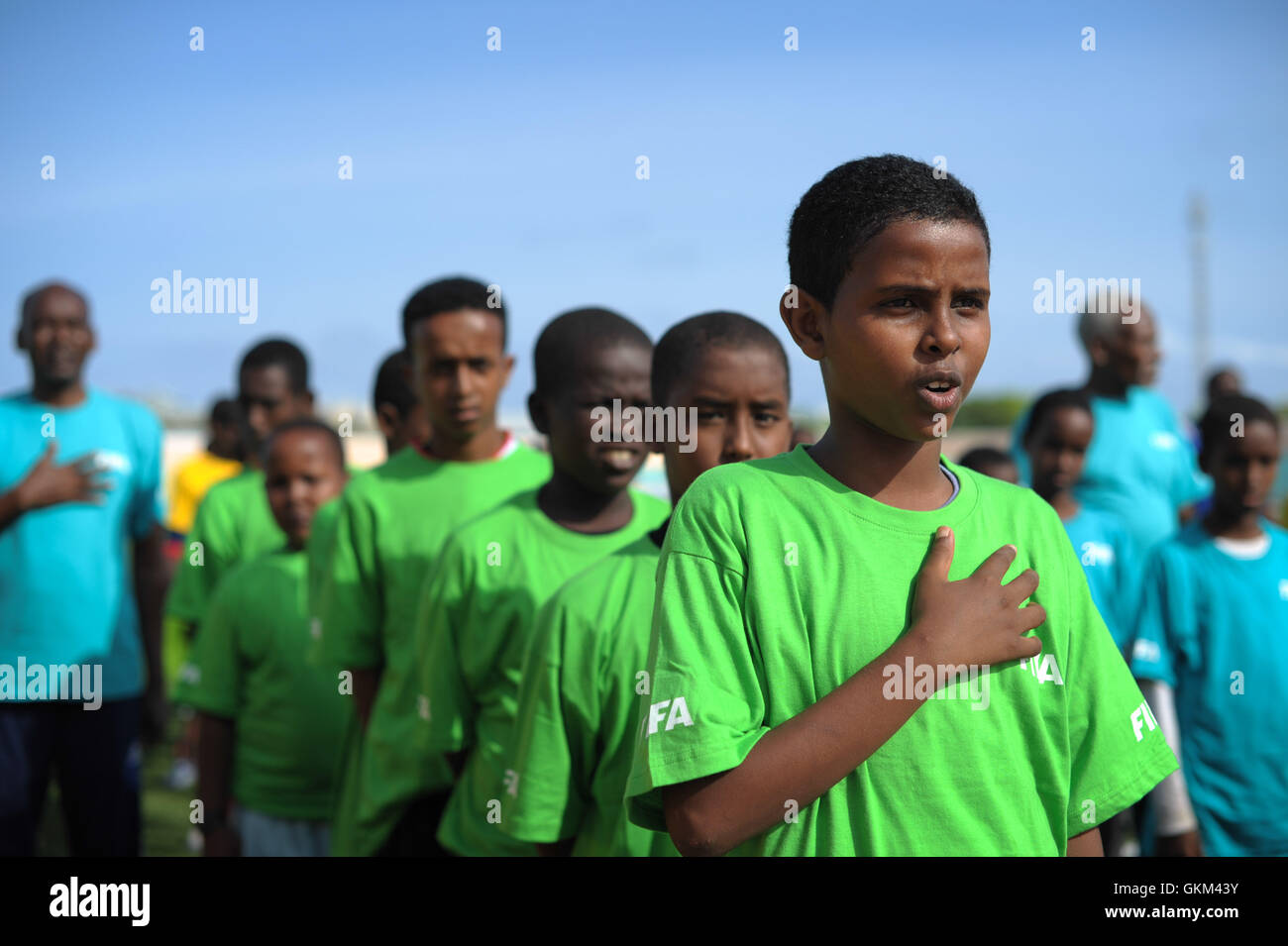 I bambini a cantare l'inno nazionale prima dell' inizio della FIFA Football Festival a Mogadiscio, Somalia, il 19 agosto. FIFA, avendo avuto nessuna presenza in Somalia per l'ultimo 26 anni, oggi ha tenuto la sua prima sessione di formazione a Mogadiscio poiché il paese è caduto in una guerra civile. Illegale sotto al Shabab, calcio ha fatto una grande rimonta in Somalia, a Mogadiscio le strade letteralmente il riempimento con i bambini ogni pomeriggio in quanto essi vengono a giocare il gioco. AU ONU IST foto / TOBIN JONES. Foto Stock