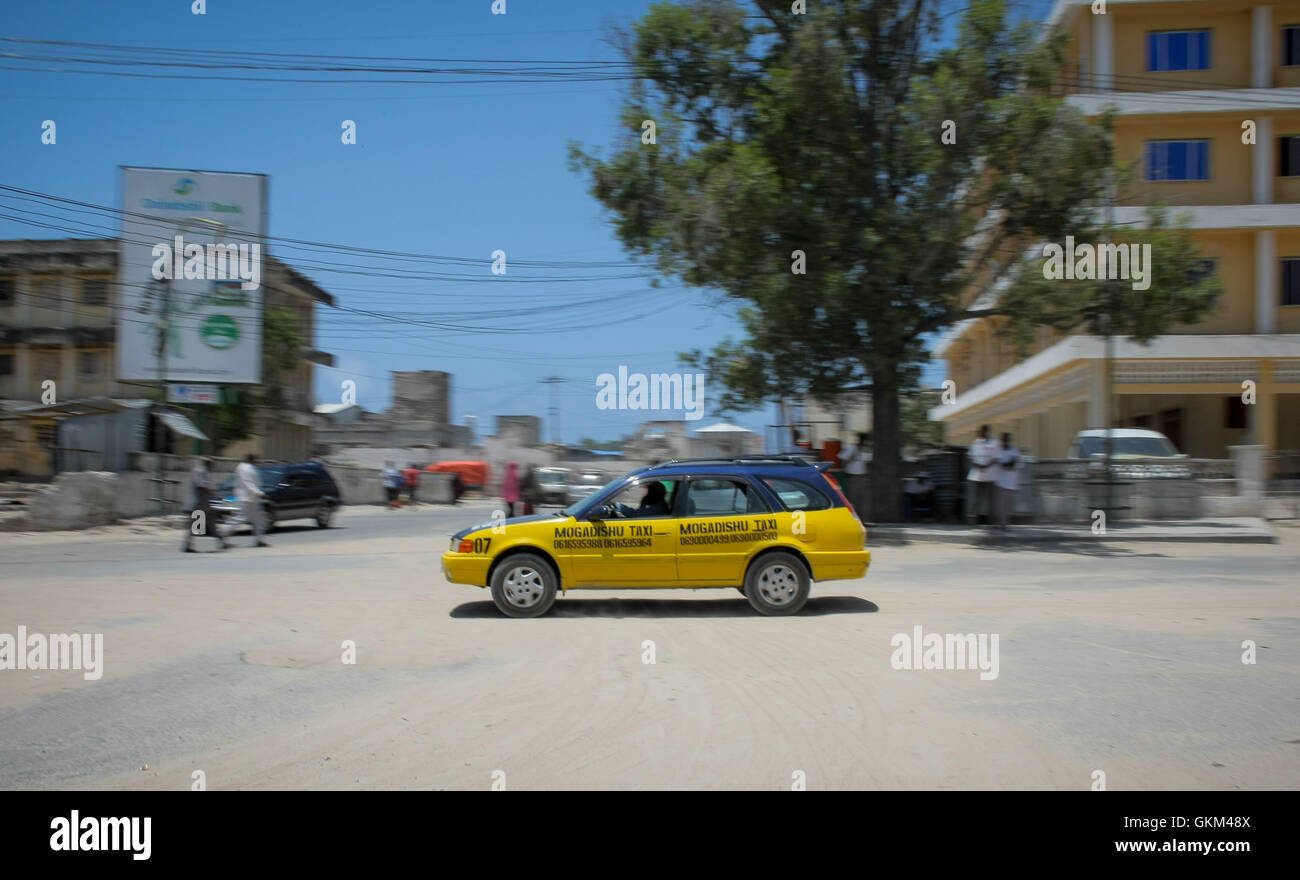 SOMALIA, Mogadiscio: In una fotografia scattata il 1 settembre 2013 e rilasciato dall'African Union-United Nazioni Informazioni sul team di supporto 02 settembre, di auto di Mogadiscio compagnia di Taxi è visto guida attraverso le strade della capitale somala Mogadiscio. Operando a partire dalla fine di Maggio di questo anno nella città del polveroso e ancora una volta vivaci strade e vie di comunicazione, la MTC è distintivo giallo e viola per auto offrono ai clienti le tariffe dei taxi attorno a Mogadiscio a tariffe competitive e nei primi 3 mesi di attività la società ha incrementato la flotta di veicoli a partire da una iniziale 25 a oltre 100. Foto Stock