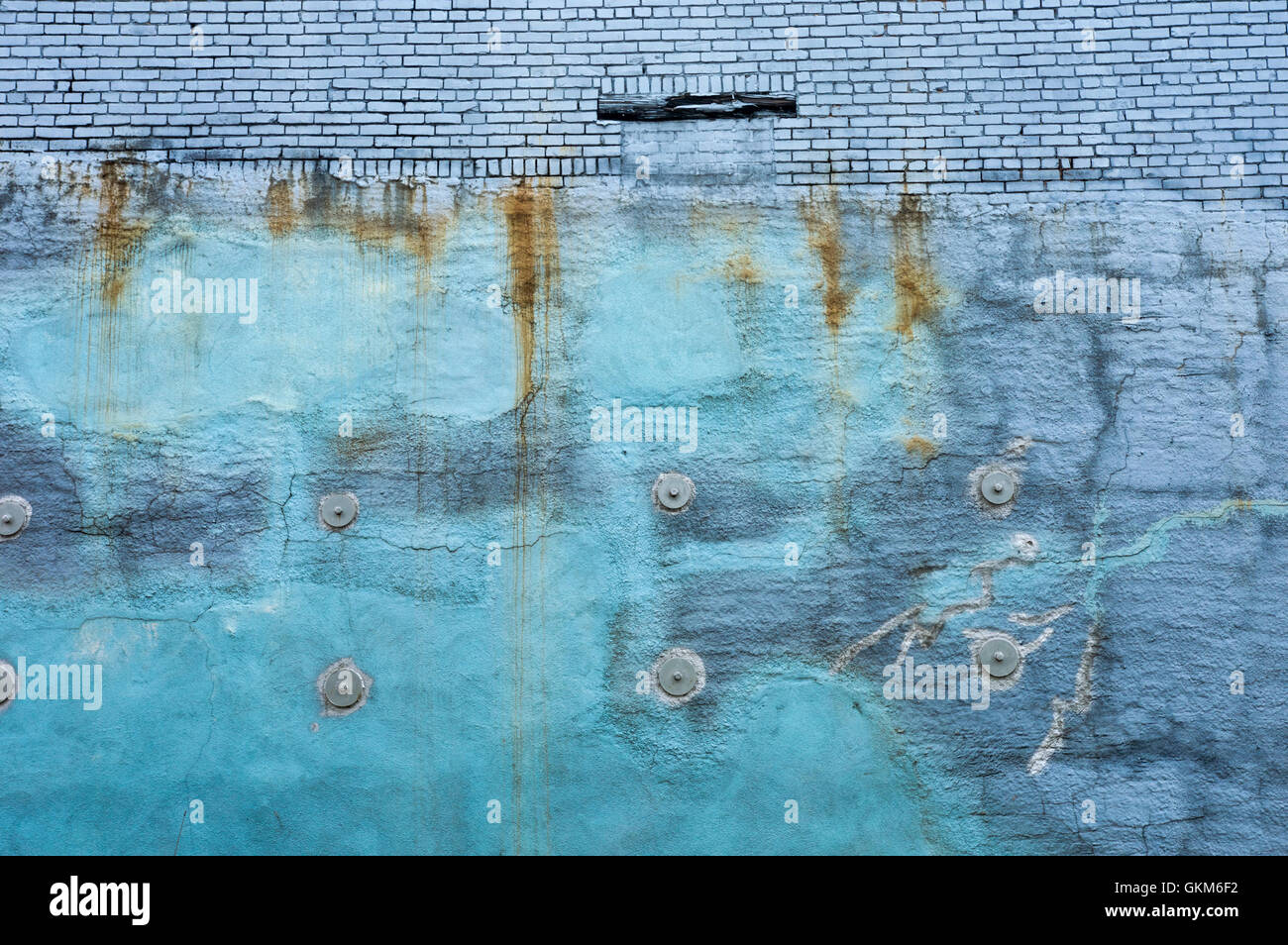 Acquamarina blu marino parete con segni di ruggine contro mattoni blu Foto Stock