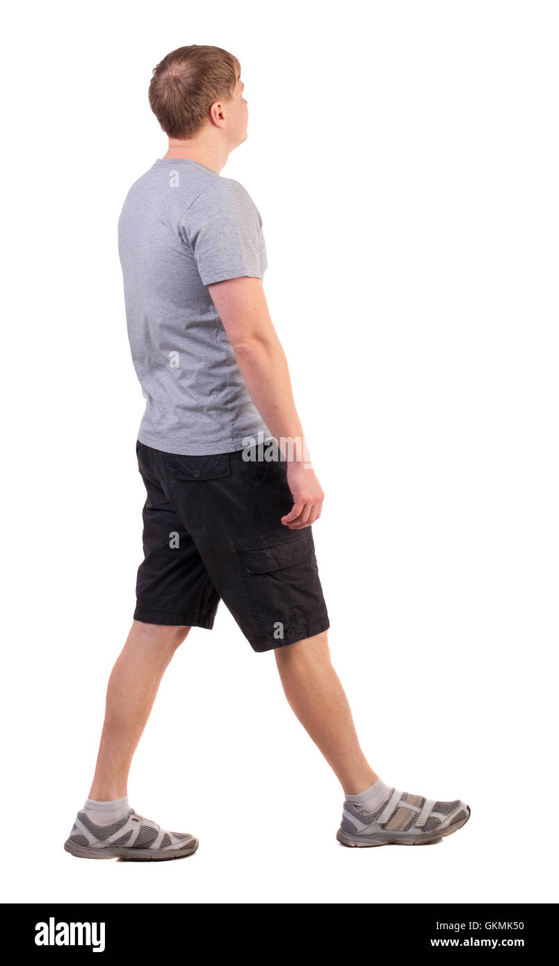 Vista posteriore del camminare uomo bello in pantaloncini corti e scarpe da  ginnastica. Sport-vestito giovane uomo si muove. andando giovane ragazzo.  Vista posteriore di raccolta persone. vista posteriore di persona. Isolato  su