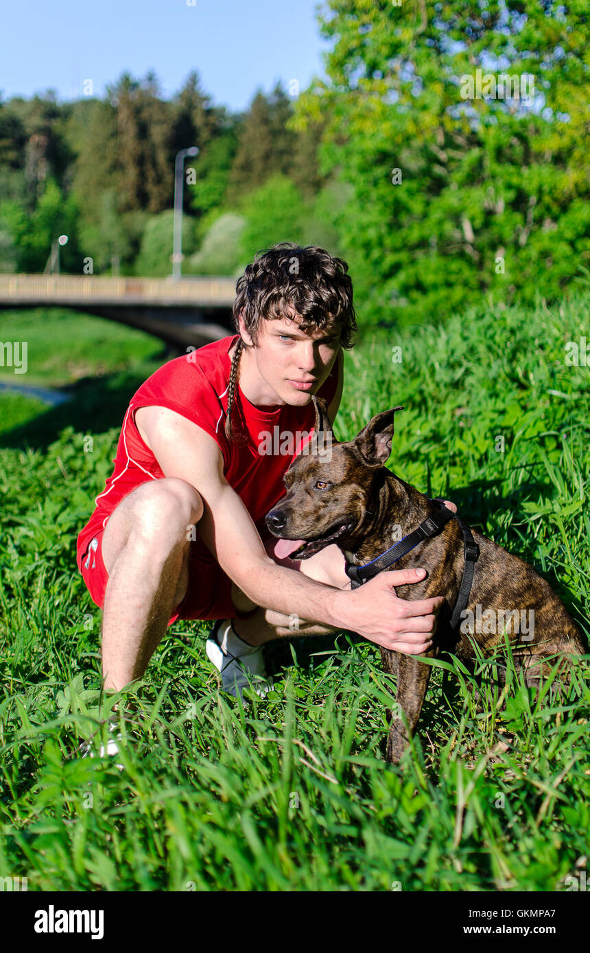 Il ragazzo seduto con la American Stafford Foto Stock