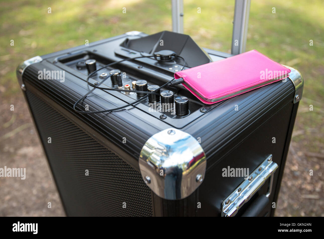 Telefono mobile collegato al portatile PA sistema audio nel parco Foto Stock