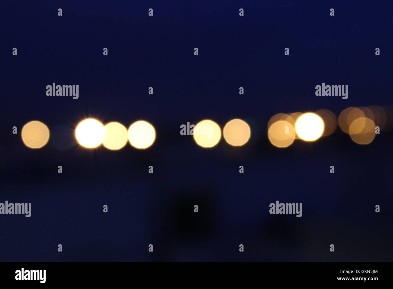 Fuori fuoco contro le luci di un blu cielo al crepuscolo Foto Stock