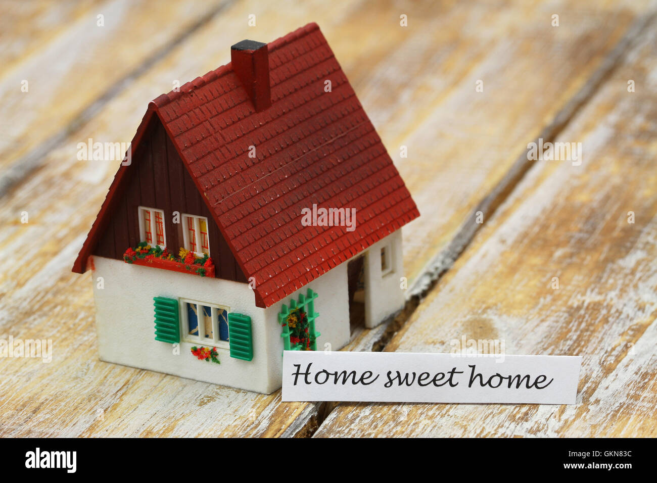 Home sweet home card con il modello in miniatura di una casa Foto Stock