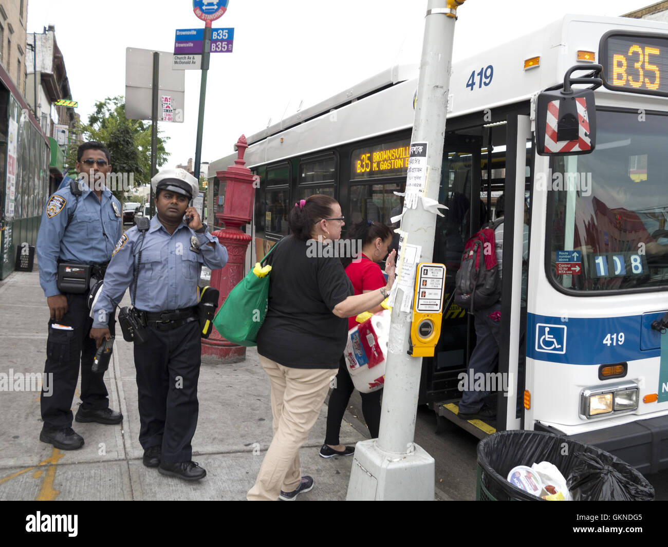 Bangladese, New York City di transito degli ufficiali di polizia presso la fermata degli autobus in 'Piccolo Bangladesh " nella sezione di Kensington di Brooklyn, New York. Foto Stock
