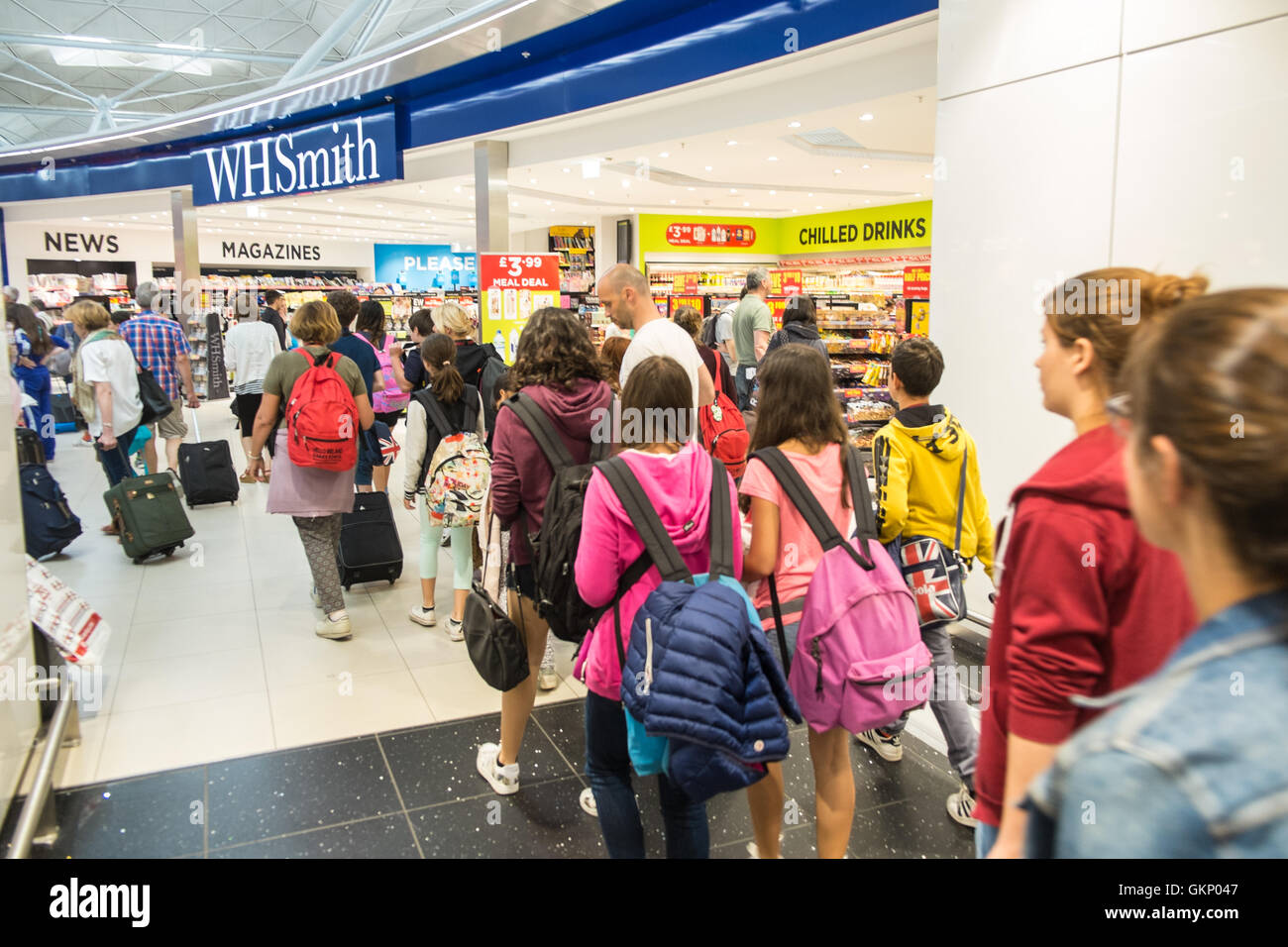 WH Smith,negozi,viaggio scolastico i bambini al terminal di partenza all'Aeroporto di Stansted, Londra,Essex, Inghilterra.L'Europa. Foto Stock