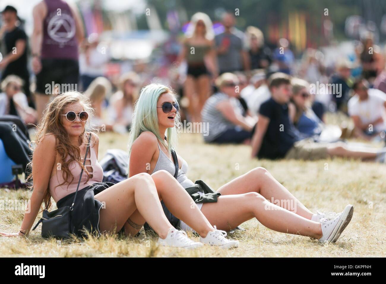 I frequentatori del festival godetevi il tempo durante il V Festival a Hylands Park a Chelmsford Essex. Foto Stock