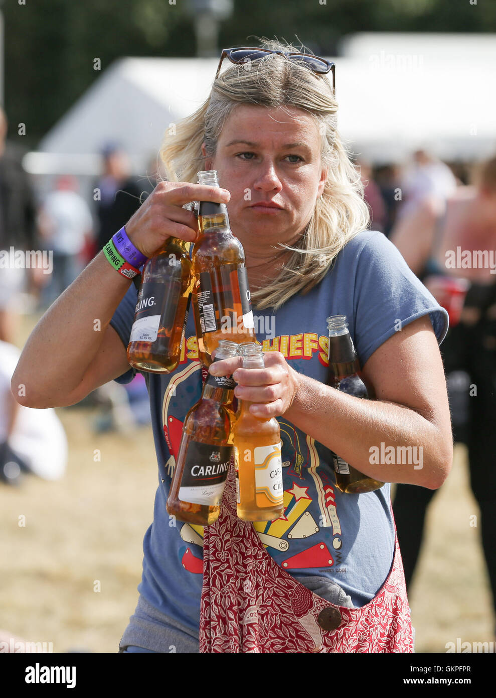 Un festival goer birre di contenimento durante il V Festival a Hylands Park a Chelmsford Essex. Foto Stock