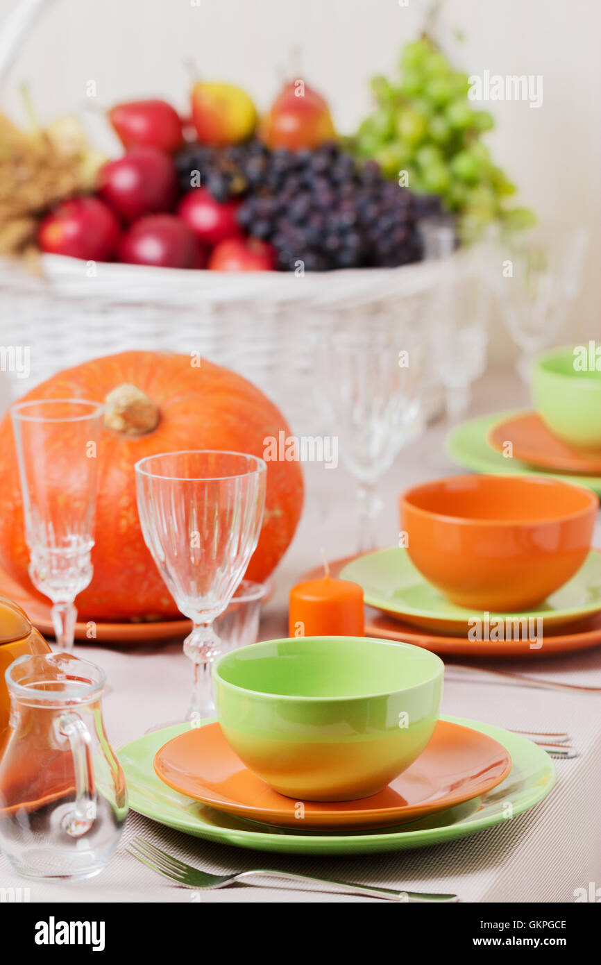 La Giornata del ringraziamento. Pranzo festivo con tradizionali decorazioni per la tavola - zucche, frutta e verdura. Impostazione tabella in arancione e Foto Stock