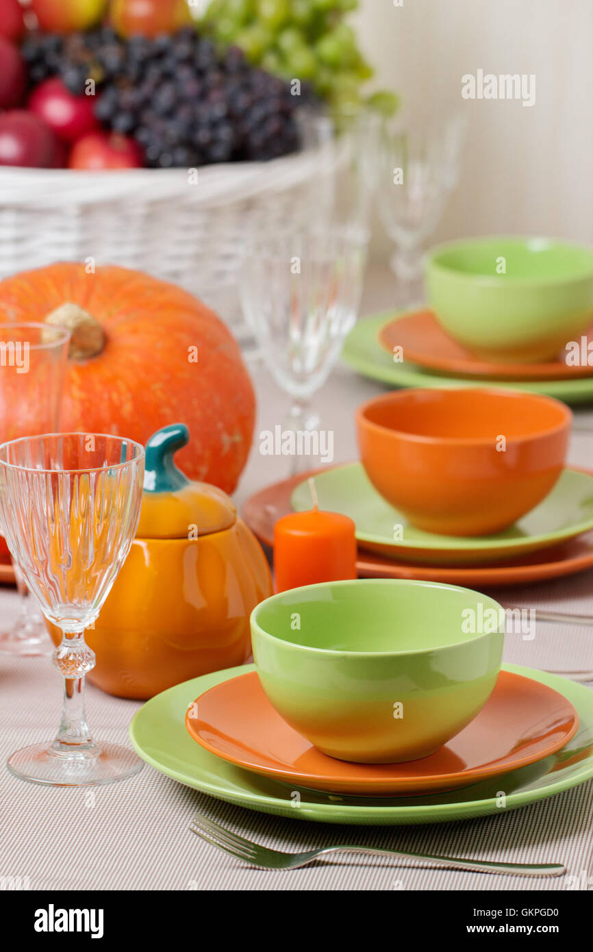 La Giornata del ringraziamento. Pranzo festivo con tradizionali decorazioni per la tavola - zucche, frutta e verdura. Impostazione tabella in arancione e Foto Stock