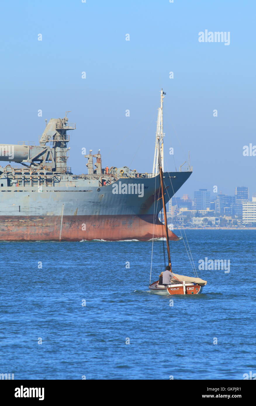 Tanker e piccola barca vela in Port Phillip Bay a Melbourne in Australia. Foto Stock