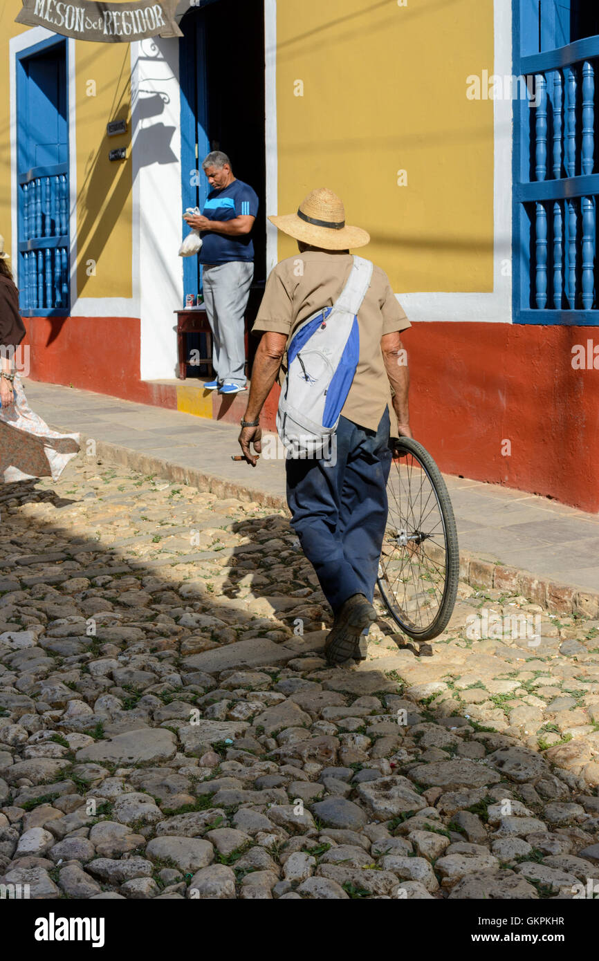 Un cubano uomo cammina lungo una strada di ciottoli in Trinidad, Sancti Spiritus provincia, Cuba Foto Stock