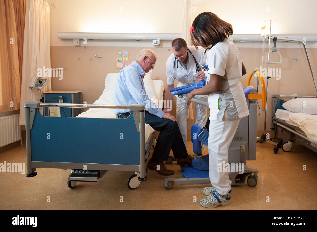 Helpen Verpleegkundigen een paziente uit bed met een til ascensore. Gli infermieri aiutare un paziente al di fuori del letto con un sollevatore attivo. Foto Stock