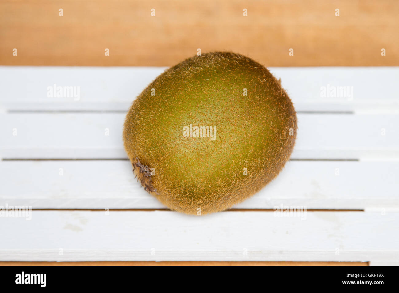 Il kiwi isolata su uno sfondo di legno. Kiwi verde Foto Stock