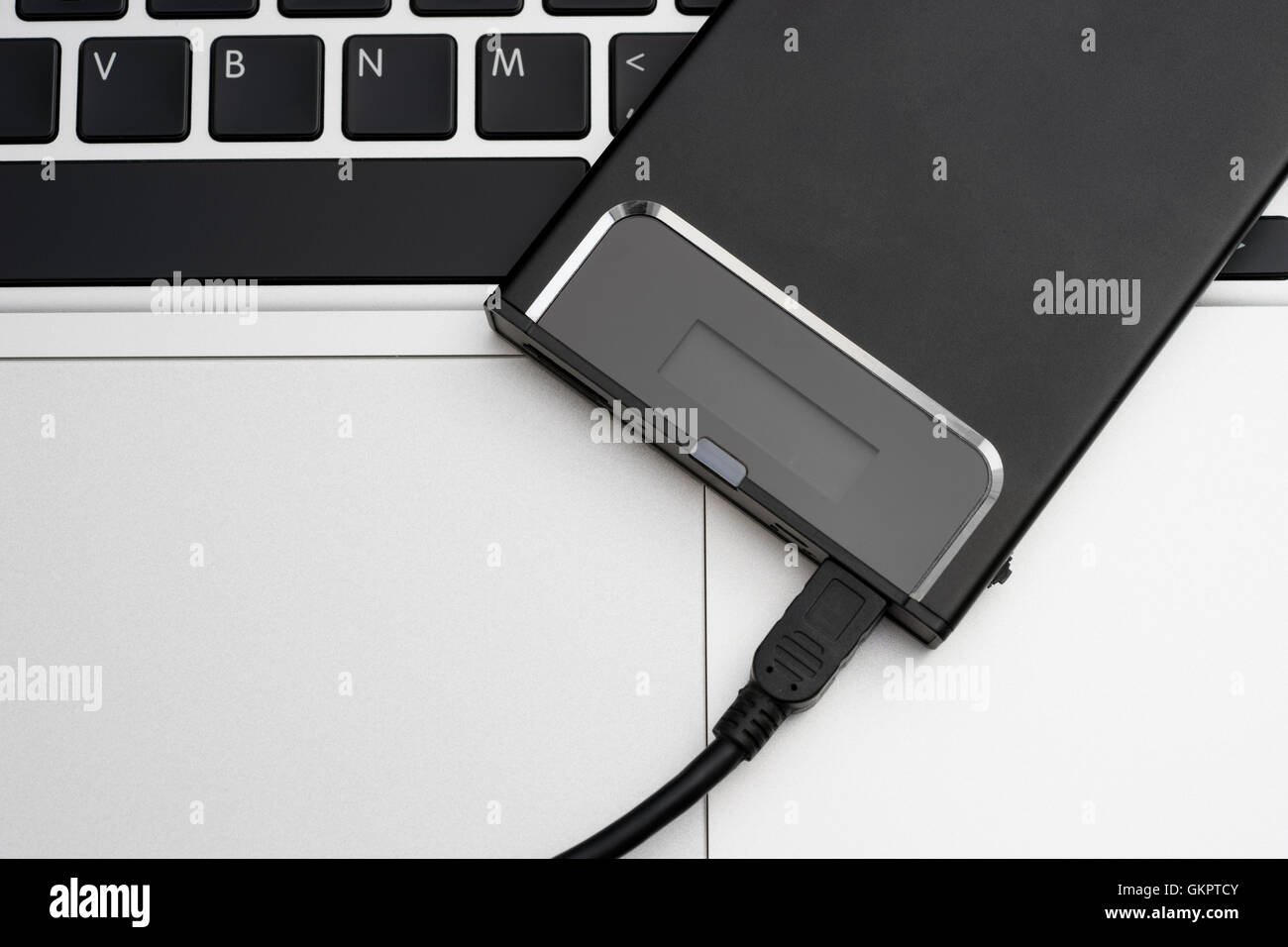 Disco rigido esterno sulla tastiera del notebook Foto Stock