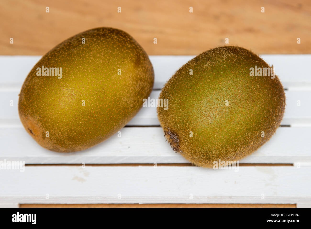 Il giallo e il verde kiwi su uno sfondo di legno. Close-up Foto Stock
