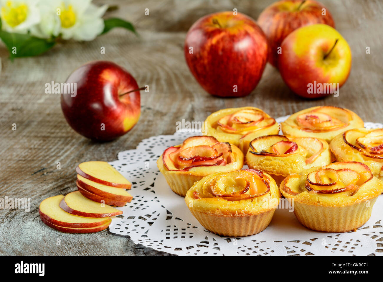 Apple rose a forma di muffin su sfondo di legno. Dolce dessert apple pie. In casa apple pasticceria Rosa. Foto Stock