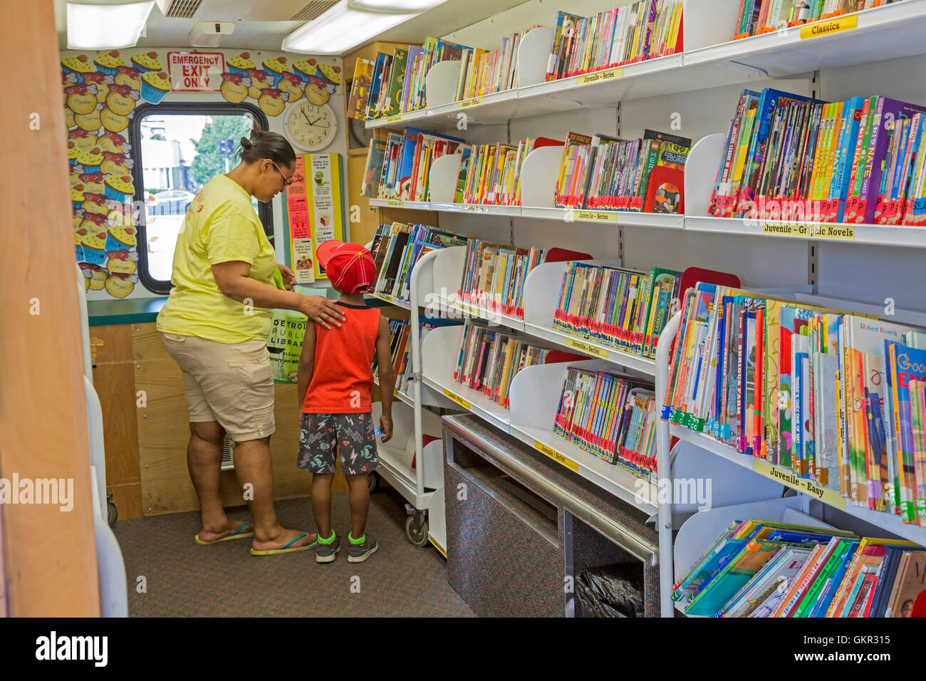 Detroit, Michigan - Un ragazzo cerca un libro in Detroit Public Library 'Libreria su ruote' durante un estate street fair. Foto Stock