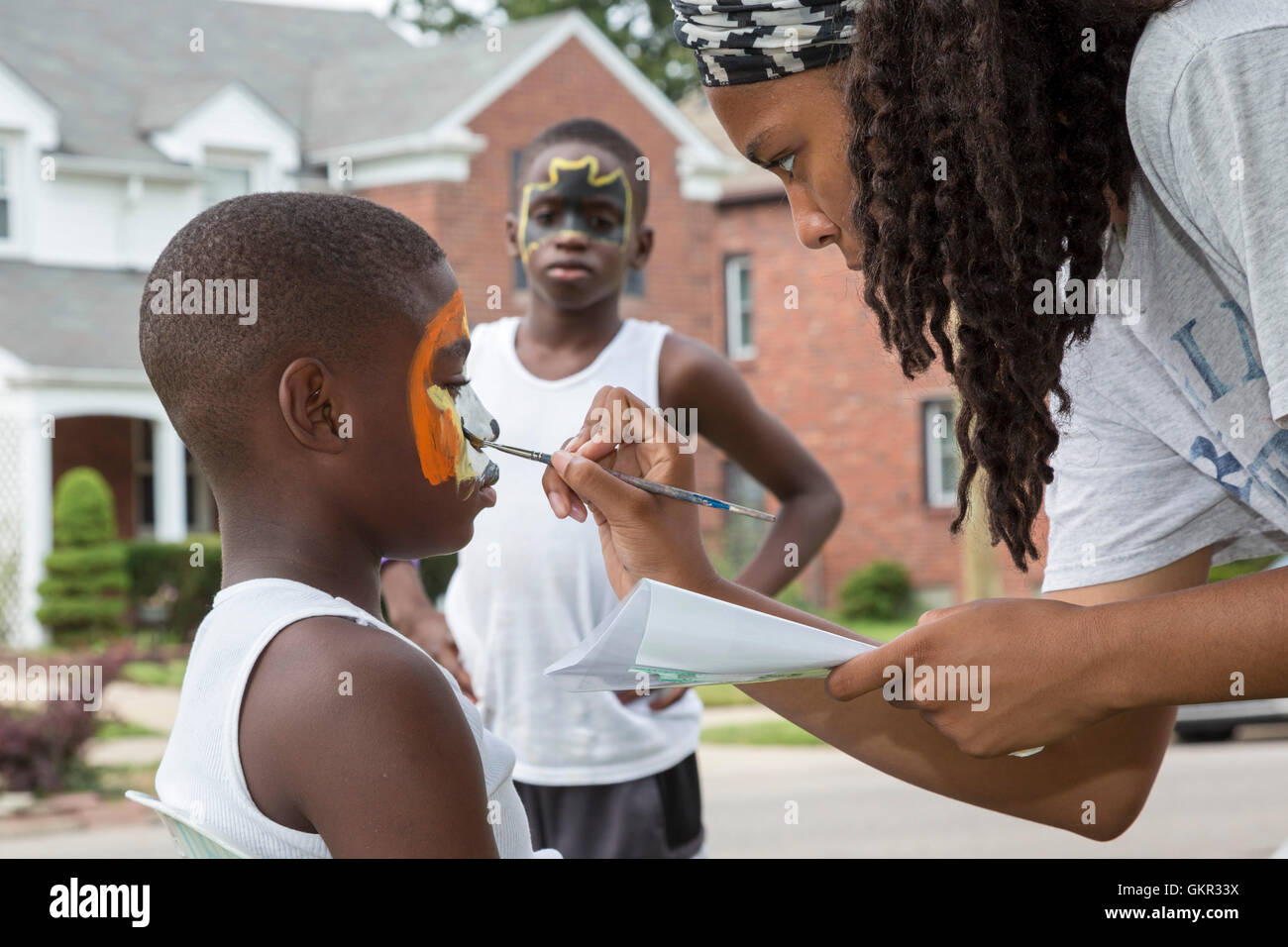 Detroit, Michigan - face painting durante un estate street fair detenute da un gruppo di quartiere. Foto Stock