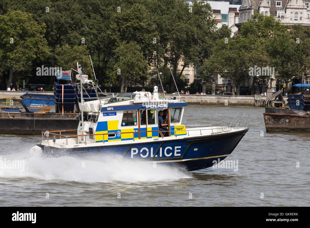 Barca di polizia accelerando sul fiume Thames, London, Regno Unito Foto Stock