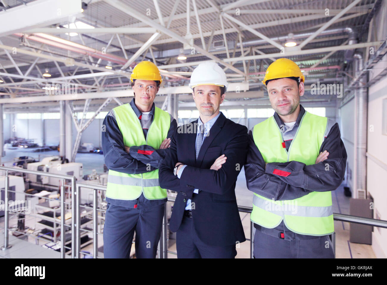 Team di manager e due lavoratori in fabbrica a CNC Foto Stock Team di manager e due lavoratori in fabbrica a CNC Foto Stock