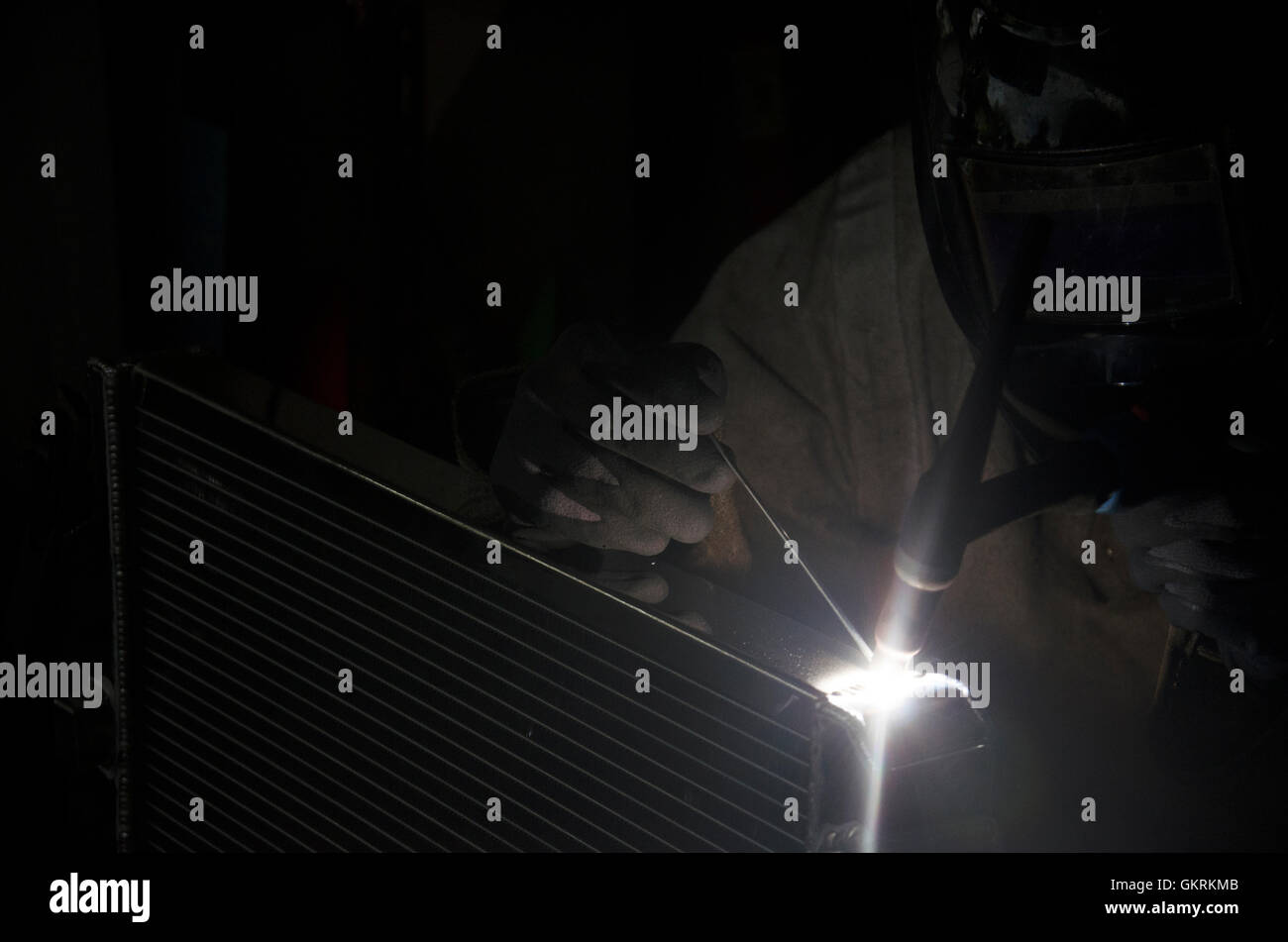 I thailandesi utilizzano l'elettricità di saldatura per fissare e saldare il radiatore di auto in garage locale a Nonthaburi, Tailandia Foto Stock