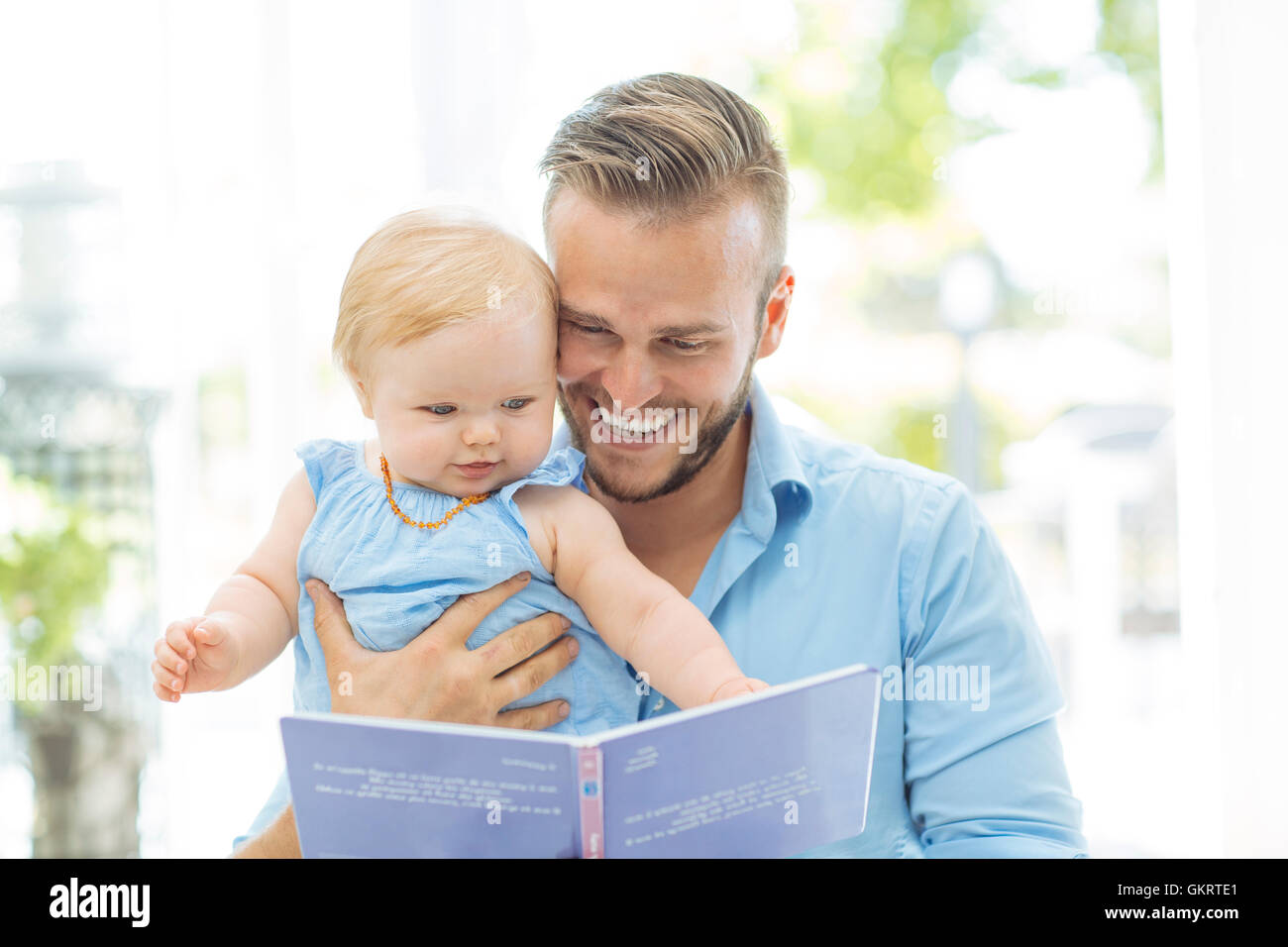 Papà la lettura di un libro con la sua bambina Foto Stock