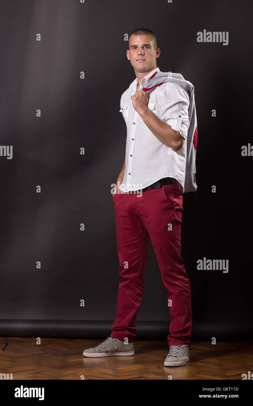 Giovane uomo classic in posa in piedi 20 anni smart abiti formali tuta maglietta pantaloni Foto Stock