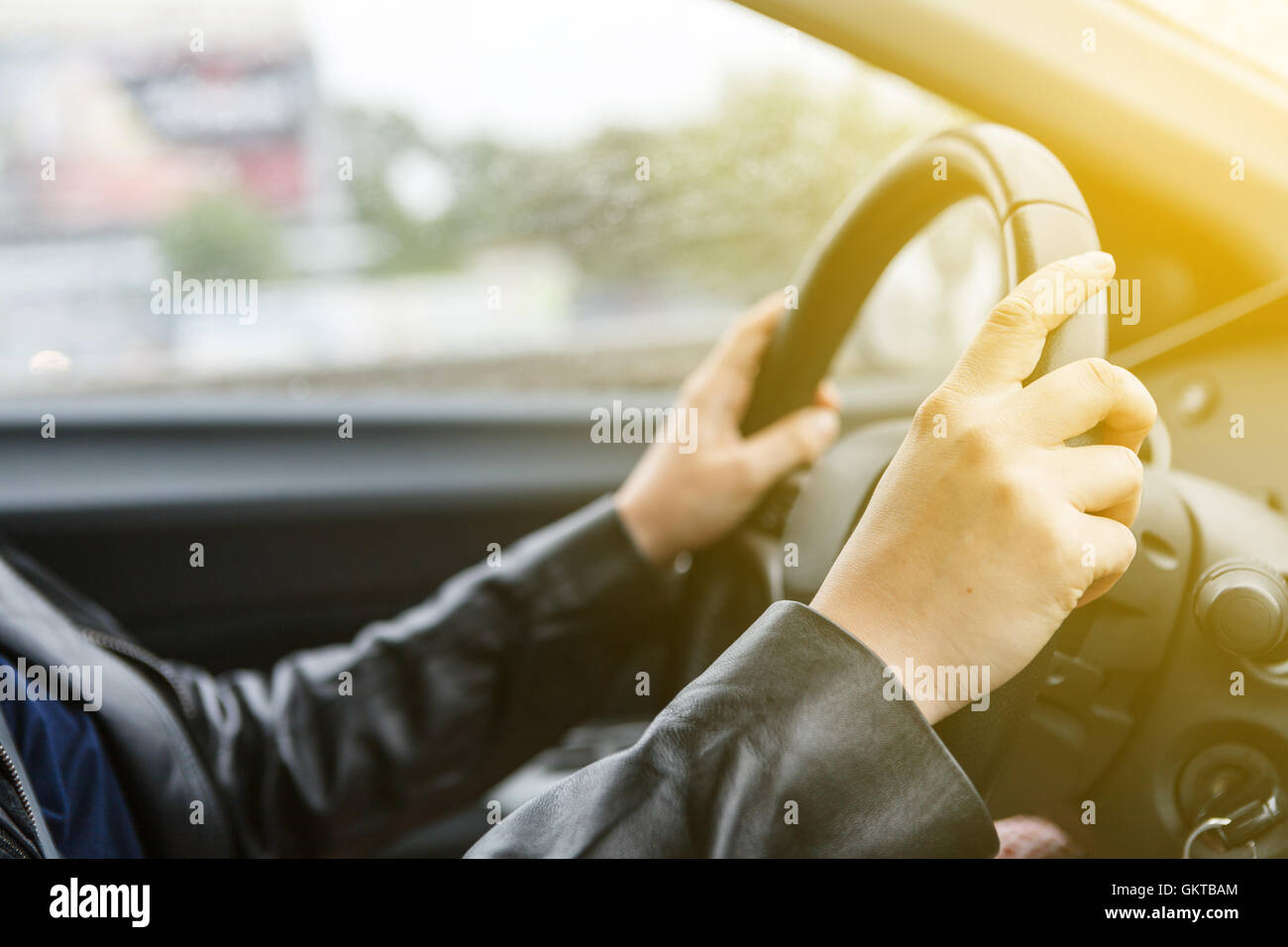 Donna alla guida di una vettura e le mani sul volante di sterzo, stile di sunrise Foto Stock
