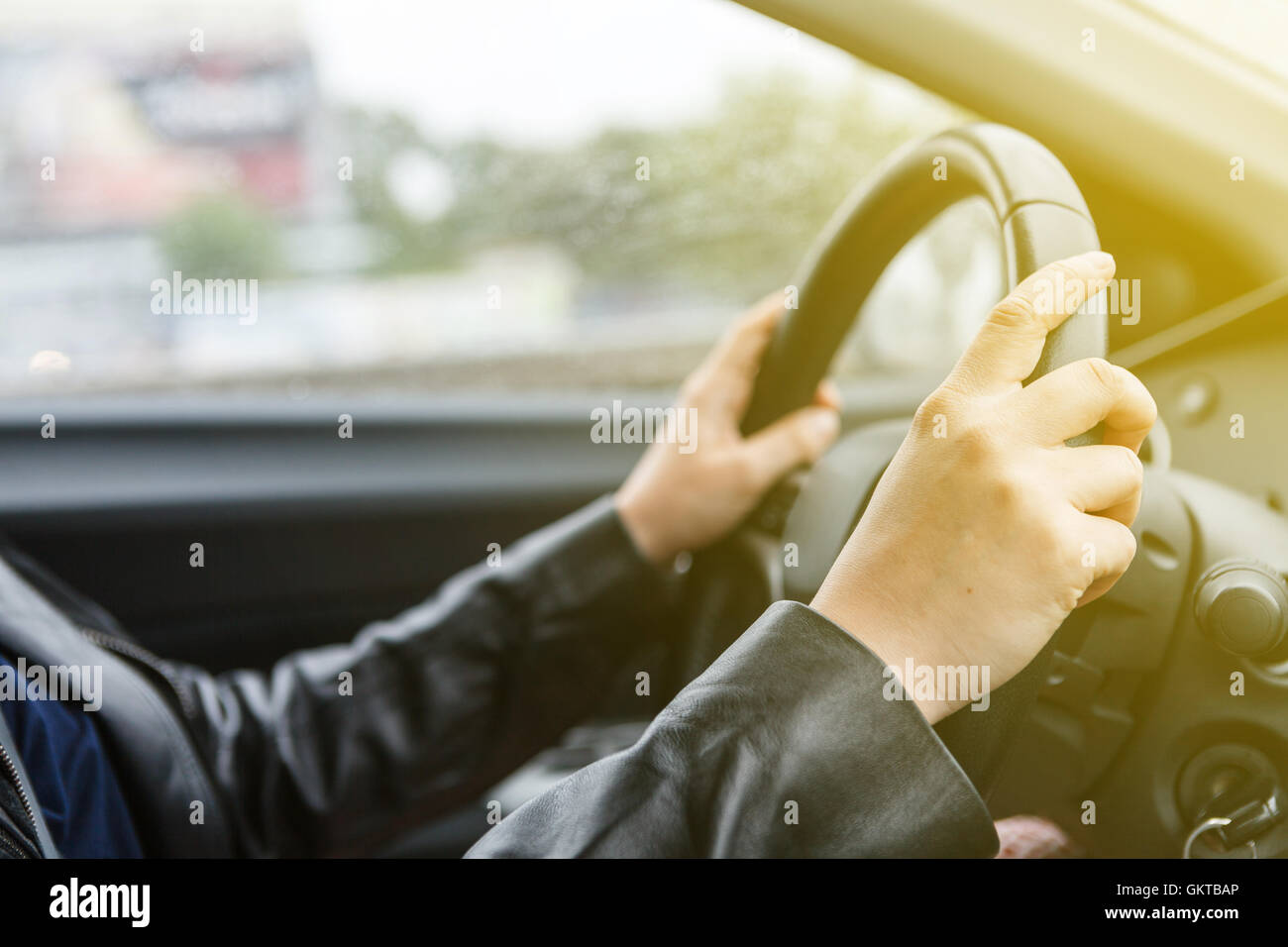 Donna alla guida di una vettura e le mani sul volante di sterzo, stile di sunrise Foto Stock