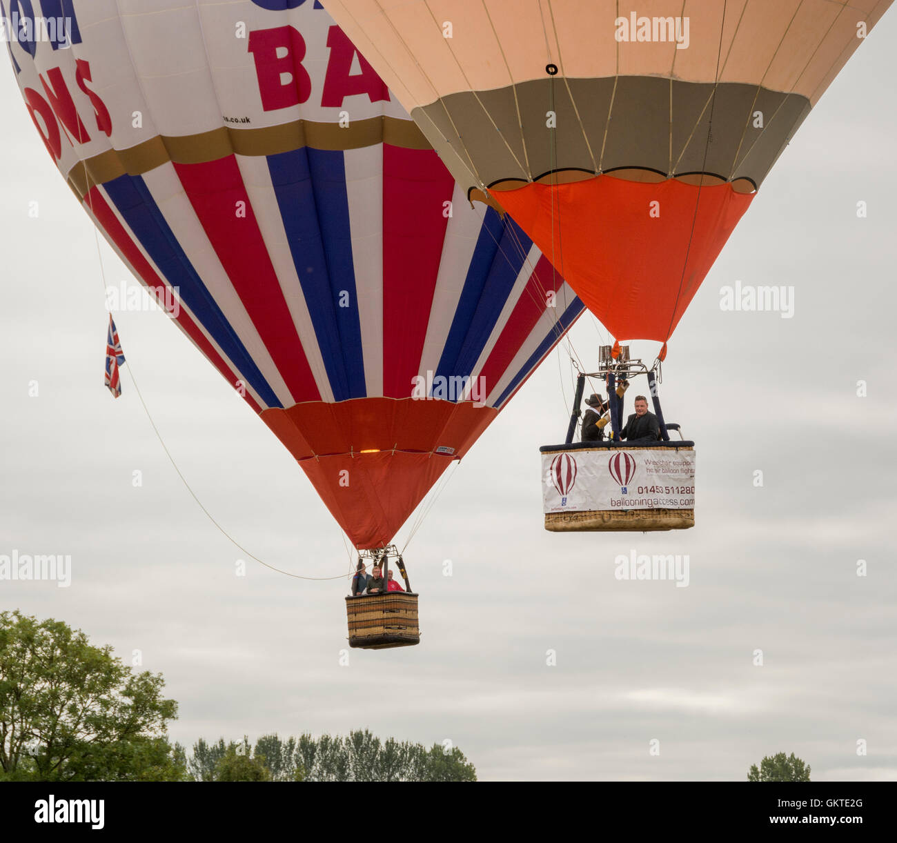 Due i palloni ad aria calda in arrivo a terra alla trentottesima annuale di Bristol International Balloon Fiesta Foto Stock
