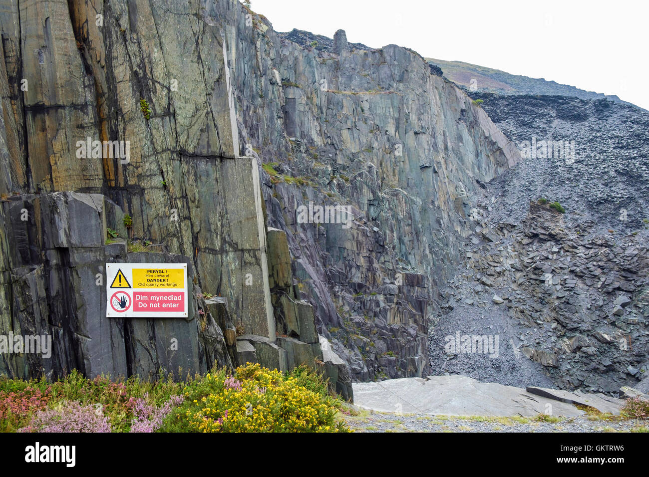 Welsh bilingue Inglese e pericolo e nessuna voce segni in disuso Dinorwig cava di ardesia. Llanberis, Gwynedd, Galles del Nord, Regno Unito Foto Stock