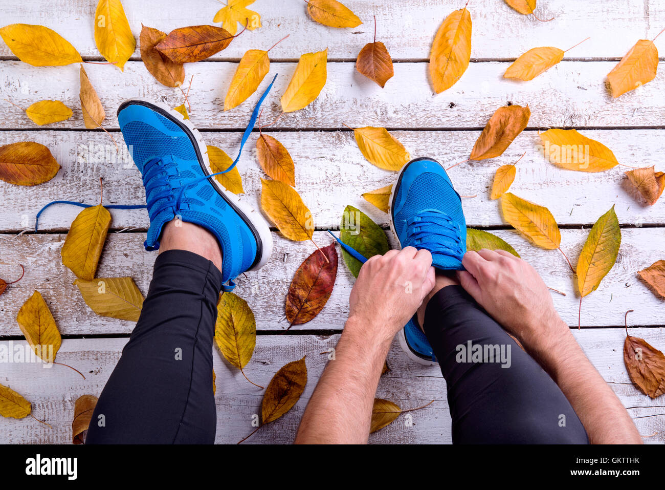 Irriconoscibile runner in calzature sportive la legatura lacci delle scarpe. In autunno le Foto Stock