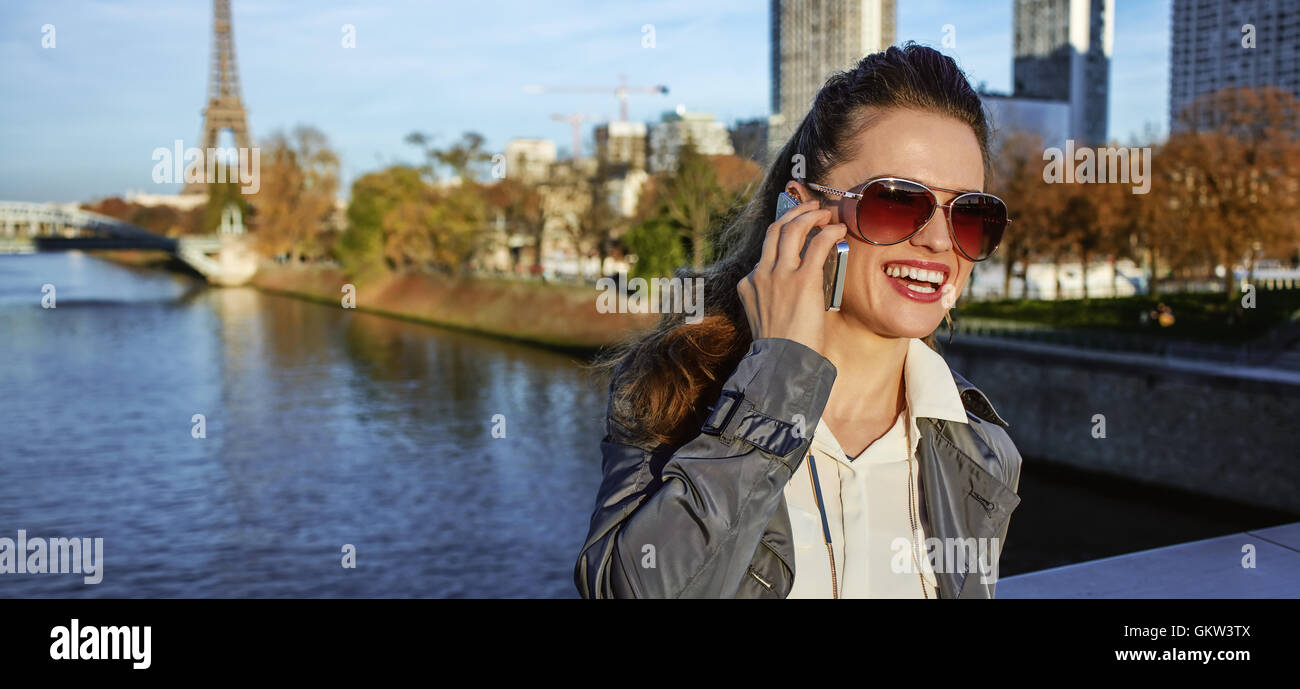 Ottieni il tuo sacchetti pronti per l'autunno a Parigi le vendite. Sorridendo moda giovane-monger in occhiali da sole parlando su uno smartphone vicino a Torre Eiffel Foto Stock