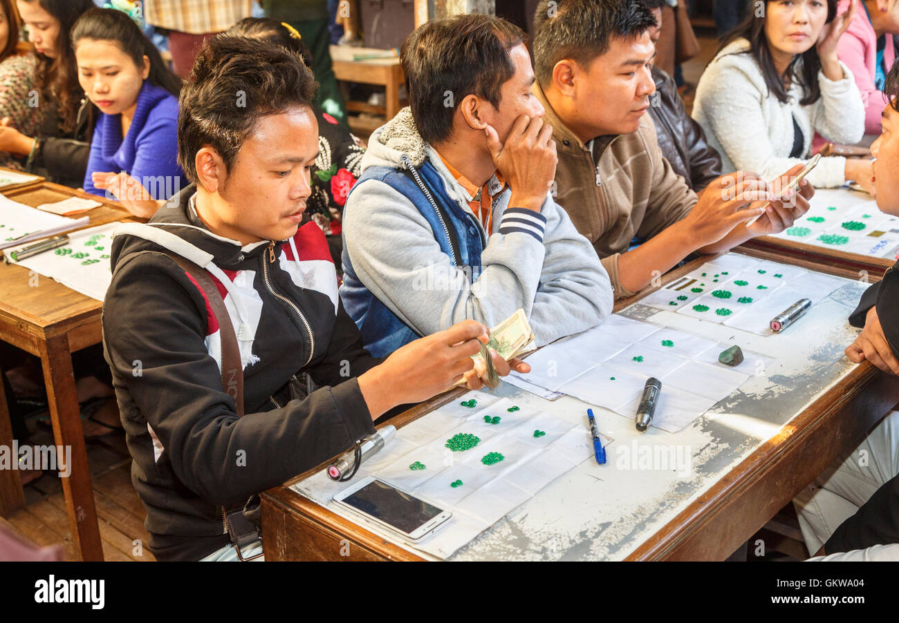 Stallholders locale la presentazione e la vendita di qualità gemma verde giada e gemme e e conteggiare denaro, Jade Market, Mandalay Myanmar (Birmania) Foto Stock