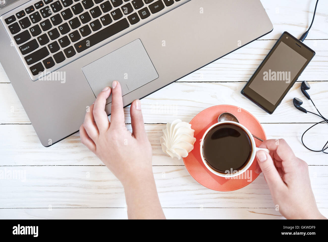 Mani femminili sulla tastiera del notebook e la tazza di caffè closeup Foto Stock