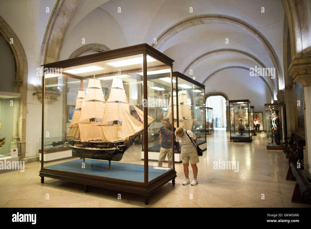 Museu de Marinha Age of Discovery Ship Model Lisbona Portogallo | LISBONA, Portogallo - Un modello di nave Age of Discovery a tre alberi, completamente equipaggiato in una cassa di vetro, viene esaminato da un visitatore al Museu de Marinha. Re Luís i, un ufficiale navale addestrato con un interesse personale per l'oceanografia, fondò il museo nel 1863; occupò l'ala occidentale neo-manuelina del monastero di Jerónimos dal 1962. Foto Stock