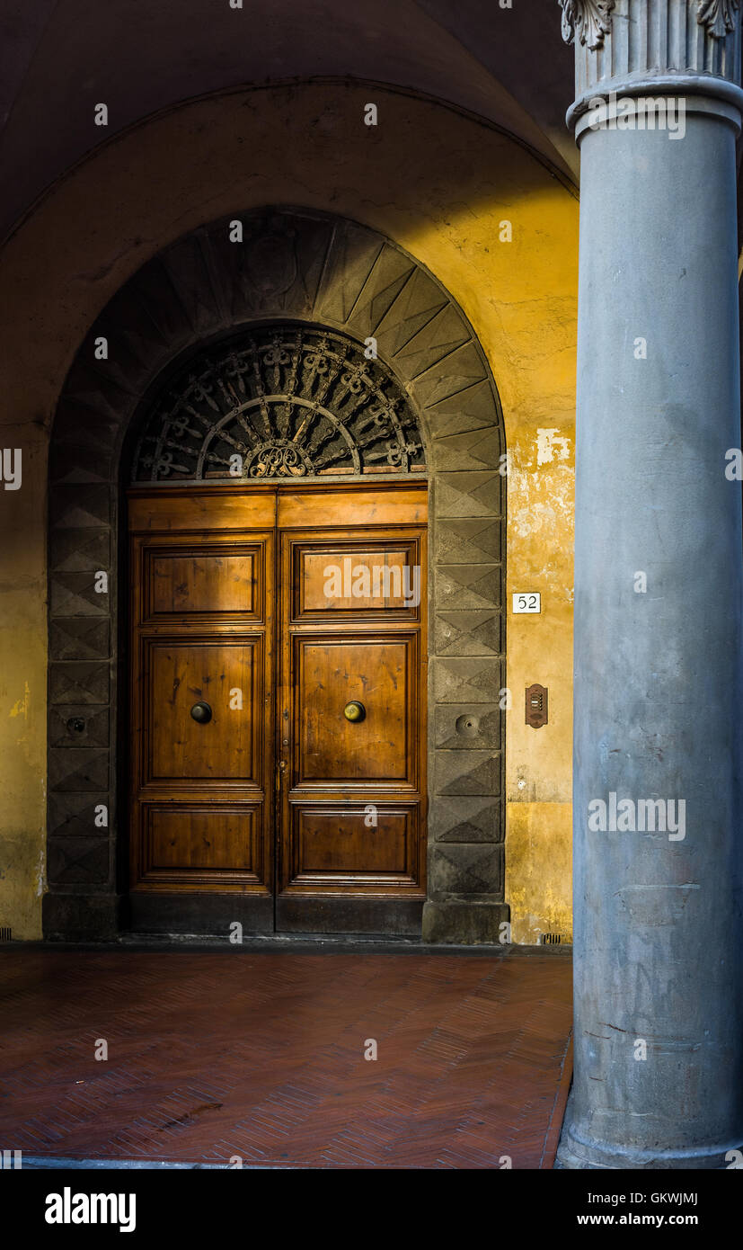 Antica porta di legno al tramonto in un arco di un Pisa street. Toscana, Italia. Foto Stock