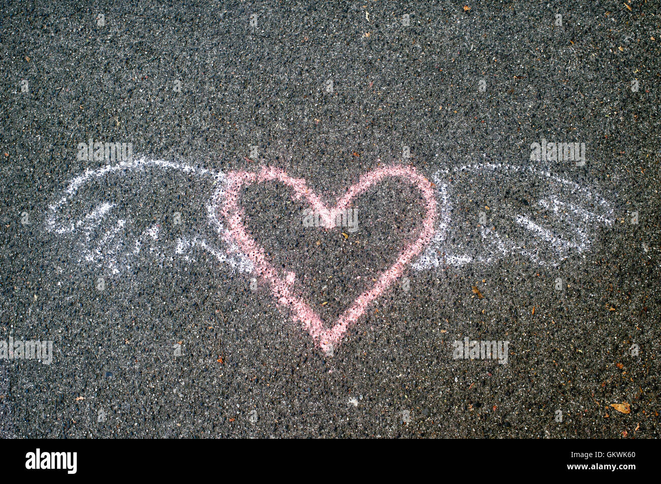 Cuore alato simbolo dipinto su un marciapiede in calcestruzzo Foto Stock