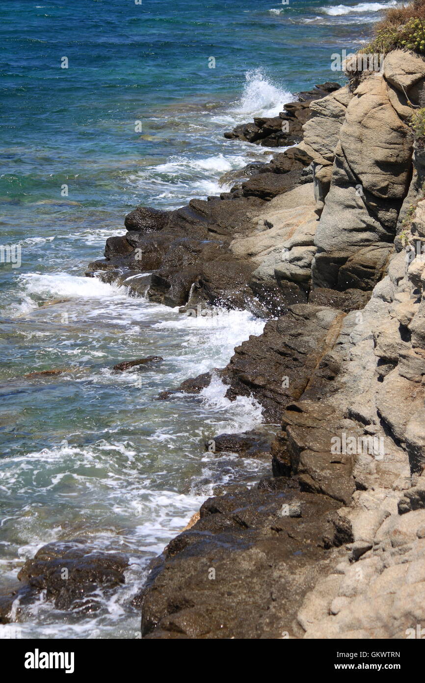 Delle onde dell'oceano urtare contro una roccia Foto Stock