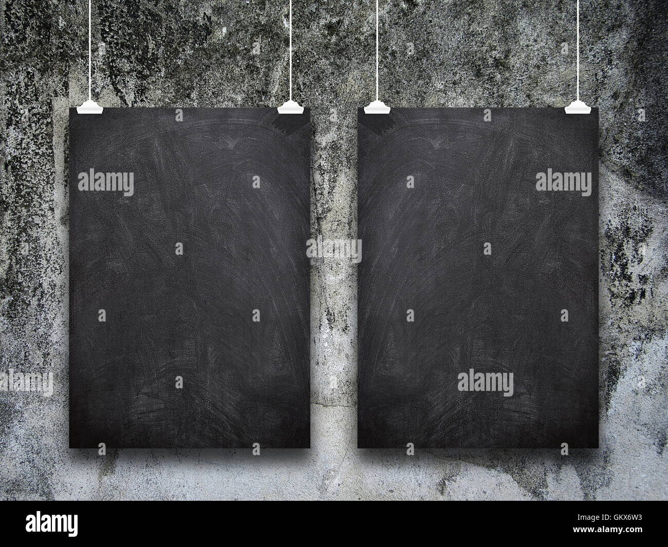 Close-up di due vuoti telaio blackboard impiccato da pioli contro il muro sporco sullo sfondo Foto Stock